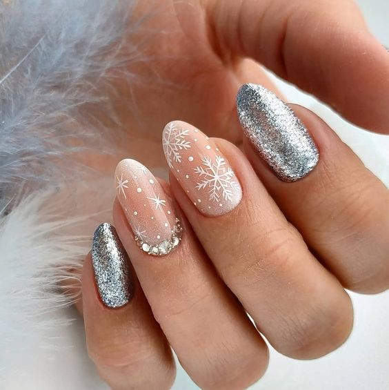 Uñas plateadas con decoraciones blancas en forma de copos de nieve; Uñas con glitter para Navidad
