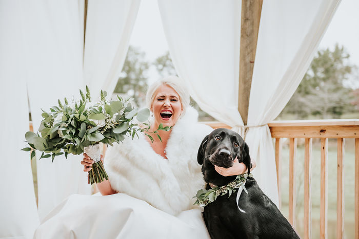 Chica posando junto a su perrito el día de su boda