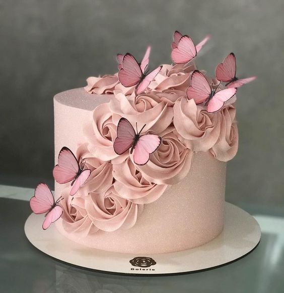 Pastel de fresas con crema en color rosa tenue, decorado con betún en forma de rosas y mariposas; Hermosos pasteles con mariposas