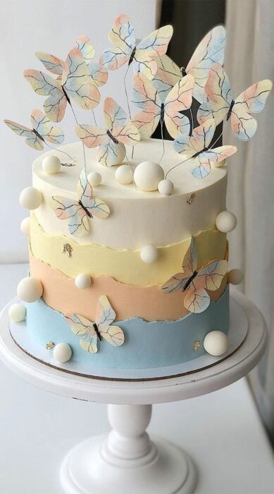 Pastel de sabores decorado con mariposas de tonos suaves; Hermosos pasteles con mariposas