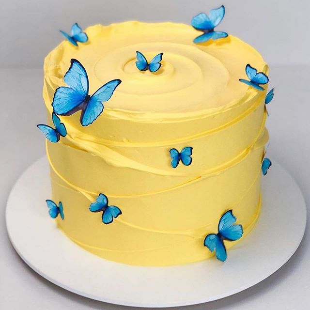 Pastel amarillo decorado con mariposas azules; Hermosos pasteles con mariposas