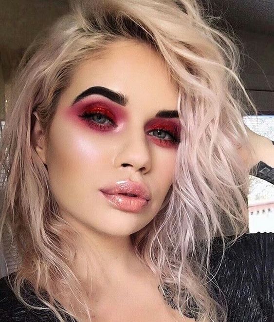 Chica rubia de melena corta rizada con gloss y smokey eye con sombra roja