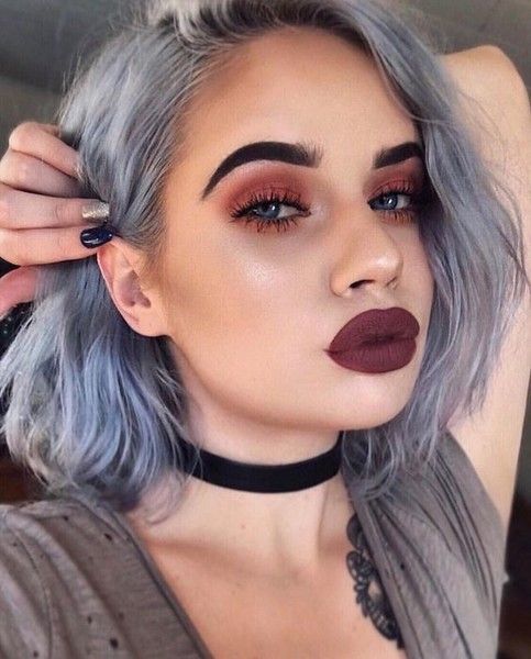 Chica de cabello corto color gris con labial en tono vino y smokey eye con sombra roja