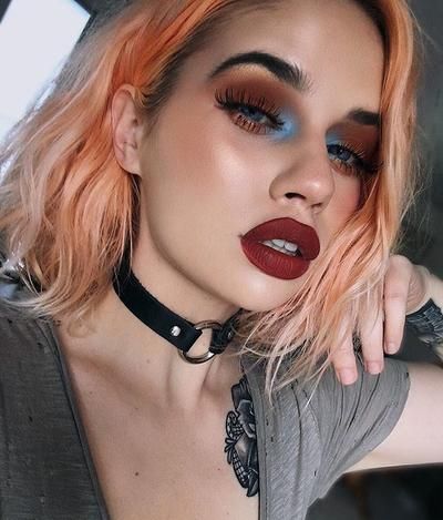 Chica de melena corta color naranja y labial rojo con sombras rojas y azul