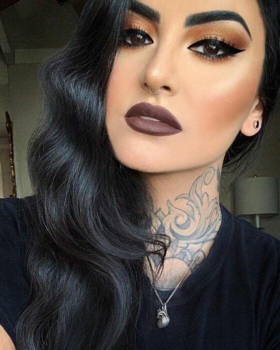 Chica morena de cabello negro largo con ondas de agua con labial café y sombras cafés con delineado negro largo