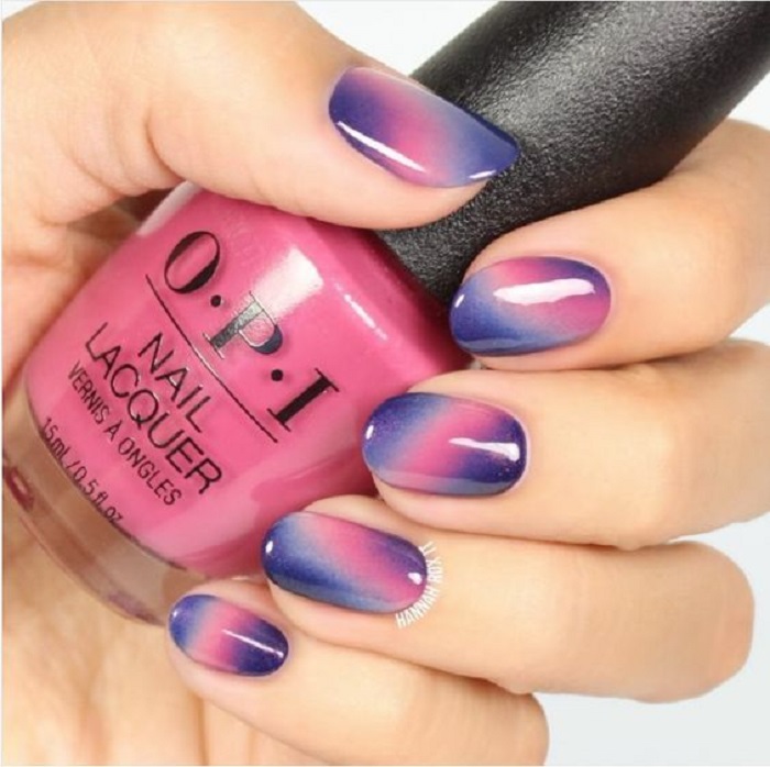 Manicura en tonos lilas con un degradado de tonalidades con brillo