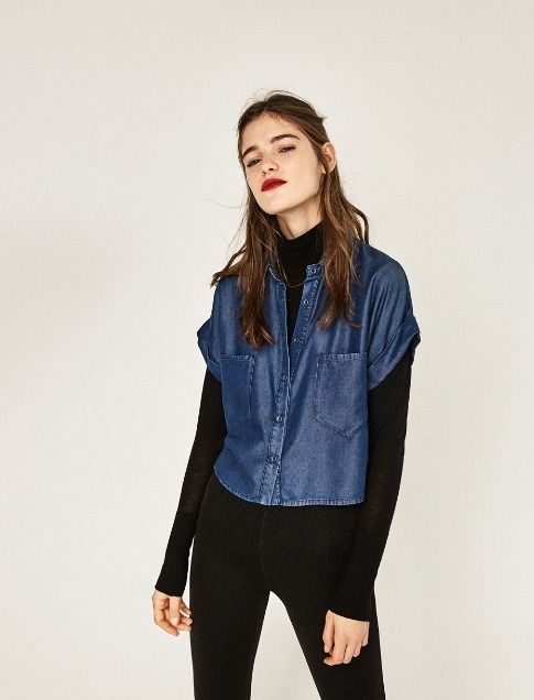 Chica con jeans y camisa de cuello alto negro, combinados con camisa de botones de mezclilla; Ideas para usar camisa de cuello alto