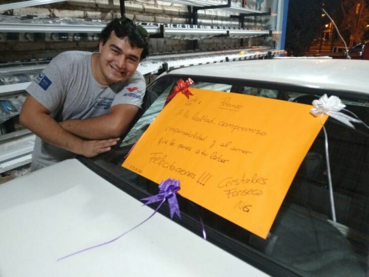 Hombre sonriendo junto a su automóvil