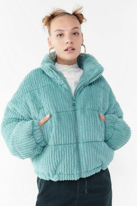 Chica con chaqueta azul turquesa, blusa blanca y pantalones negros