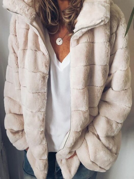 Chica con chaqueta peluda beige, blusa blanca y jeans