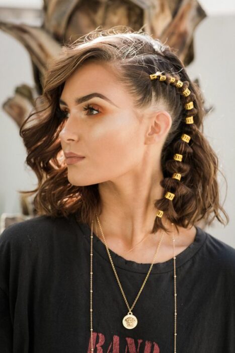 Chica con peinado trenzado lateral y argollas doradas; Peinados con argollas