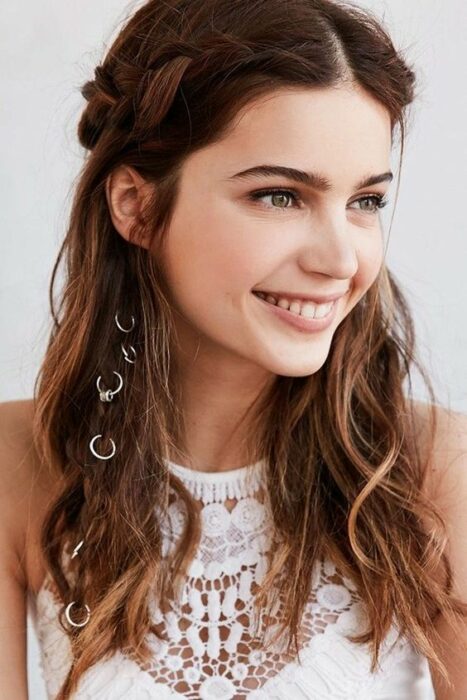 Chica con cabello suelto y trenza lateral con argollas; Peinados con argollas