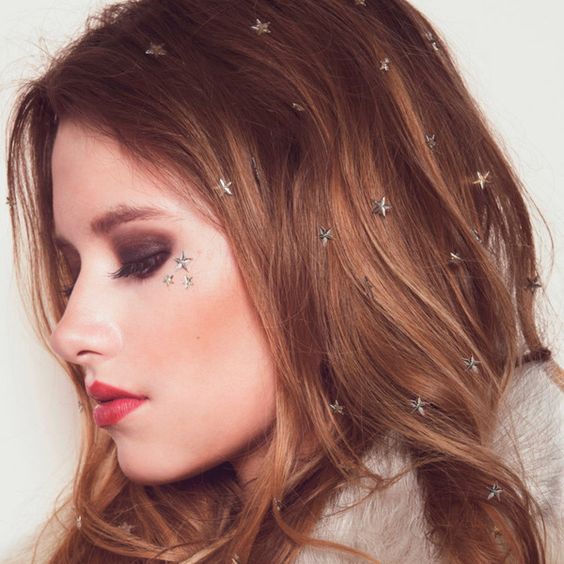 Chica con cabello suelto y argollas en forma de estrellas; Peinados con argollas