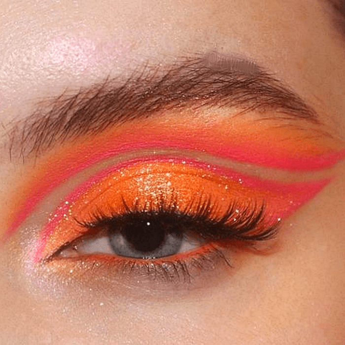 maquillaje naranja con sombras amarillas, naranjas y rojas, delineado gráfico y pestañas postizas