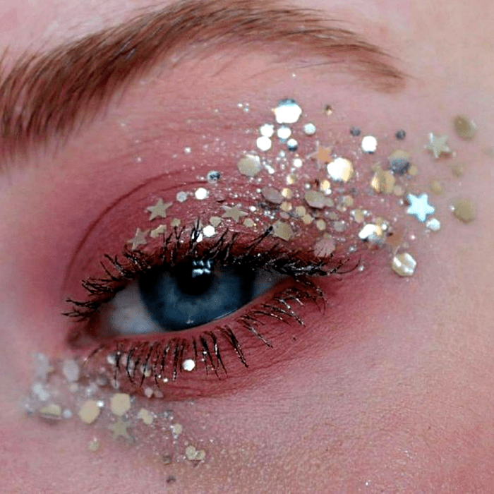 maquillaje con sombras rosas y glitter plateado en forma de estrellas