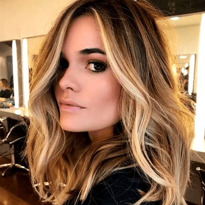 chica de cabello claro con ojos cafés, con mechas doradas estilo money piece