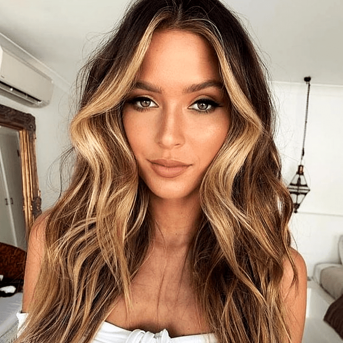 chica bronceada de cabello castaño con mechas y highlights estilo money piece