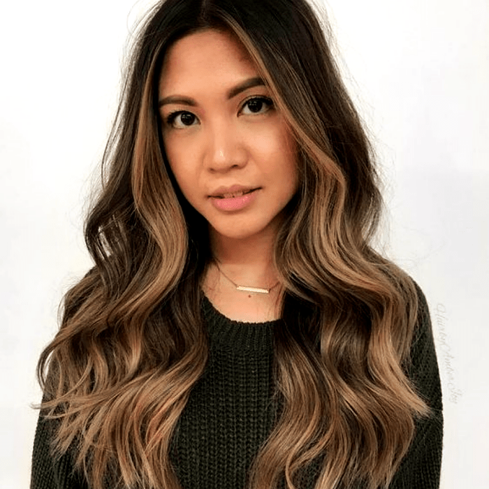 chica de cabello castaño largo con highlights y mechas estilo money piece