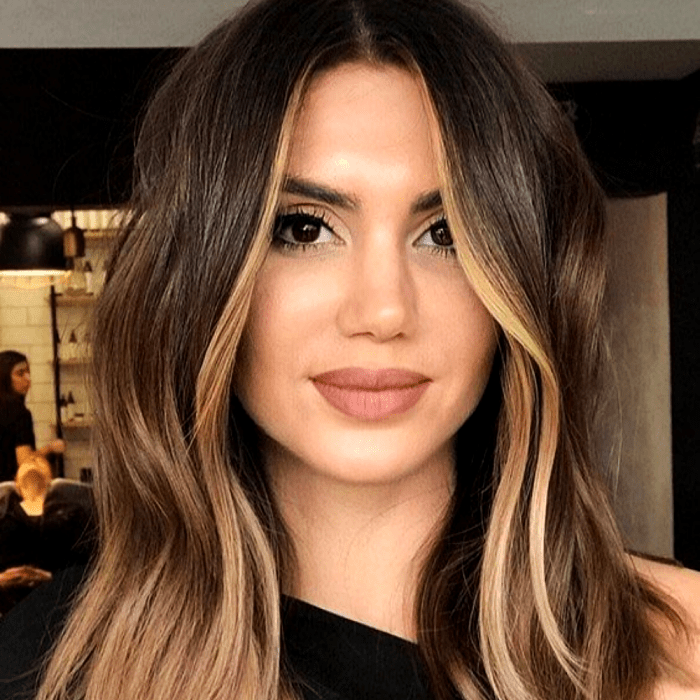 chica de cabello castaño con mechas y hightlights estilo money piece