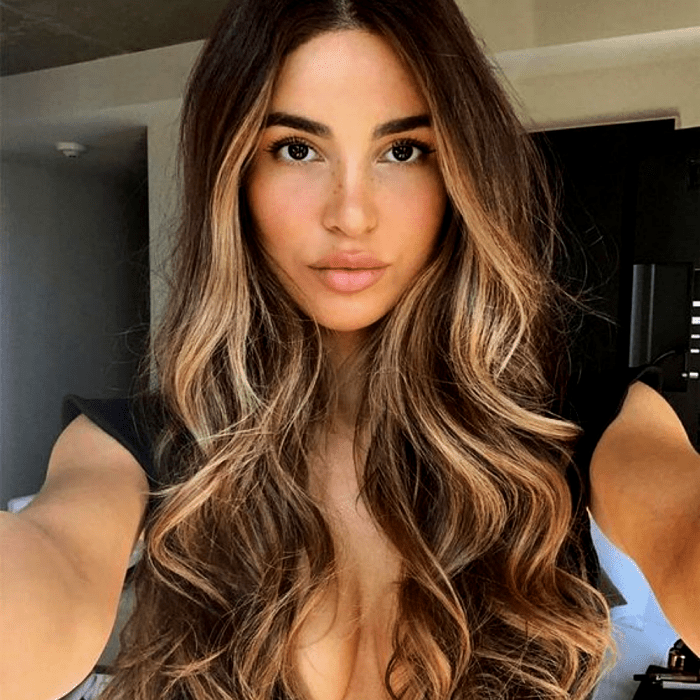chica de cabello castaño largo con cabello teñido de mechas y hightlights estilo money piece
