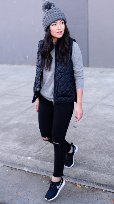 Chica con jeans y chaleco negro a juego; ideas para llevar chaleco durante el otoño-invierno