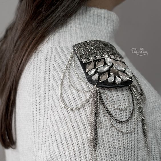 Chica llevando hombreras con pedrería en color gris sobre un suéter a juego; Hombreras para decorar tus prendas