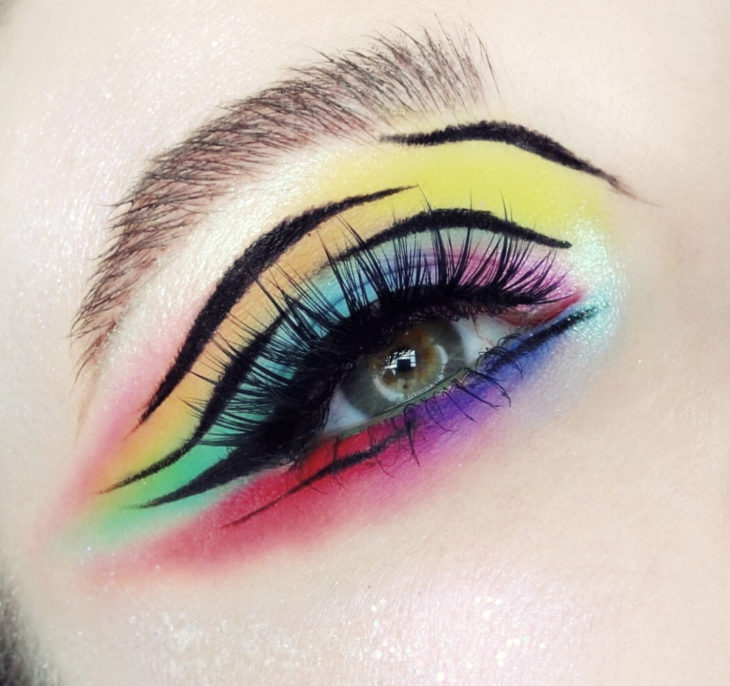 Maquillaje de arcoíris en colores azul, morado, amarillo, naranja, rosa con efecto animal print en delineado negro