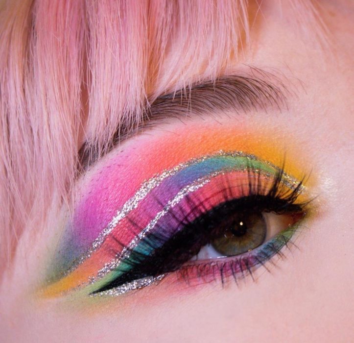 Maquillaje de arcoíris en colores azul, morado, amarillo, naranja, rosa con delineado plateado