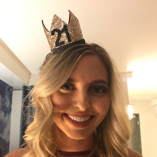 Chica rubia con coronita dorada con el número 21