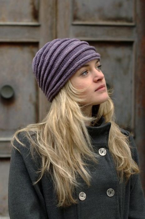 Chica llevando gorro tejido en color morado; ideas para llevar gorros y sombreros en otoño
