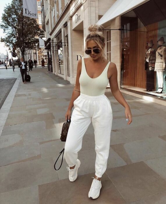 Chica usando pantalones sueltos, top de color beige y tenis