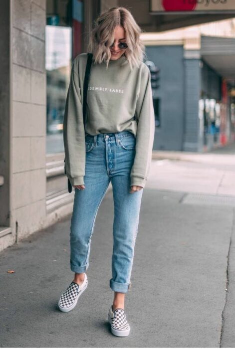 Chica usando jeans, tenis y una blusa de manga larga en color verde