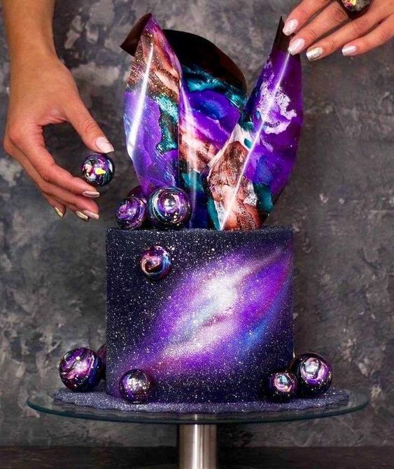 Pastel decorado en tonos morados y negros con esferas galácticas; Pasteles inspirados en la galaxia