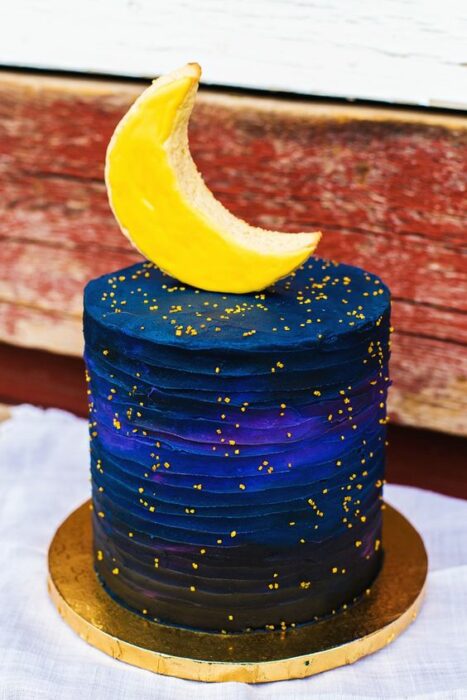 Pastel decorado con una media luna, con cobertura y chispas amarillas; Pasteles inspirados en la galaxia