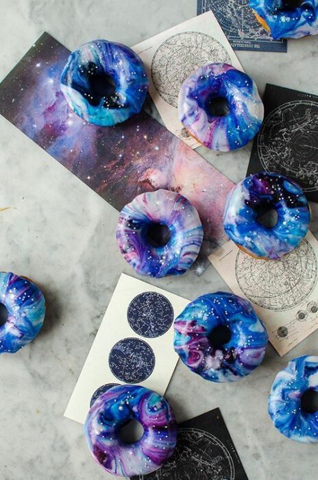 Rosquillas decoradas con glaseado en blanco y morado; Pasteles inspirados en la galaxia
