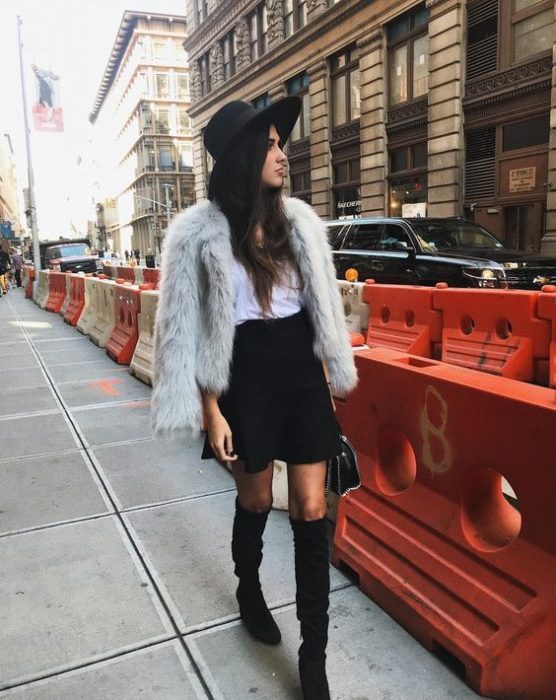 Chica de cabello largo suelto con sombrero, blusa blanca, chamarra de mezclilla y falda negra