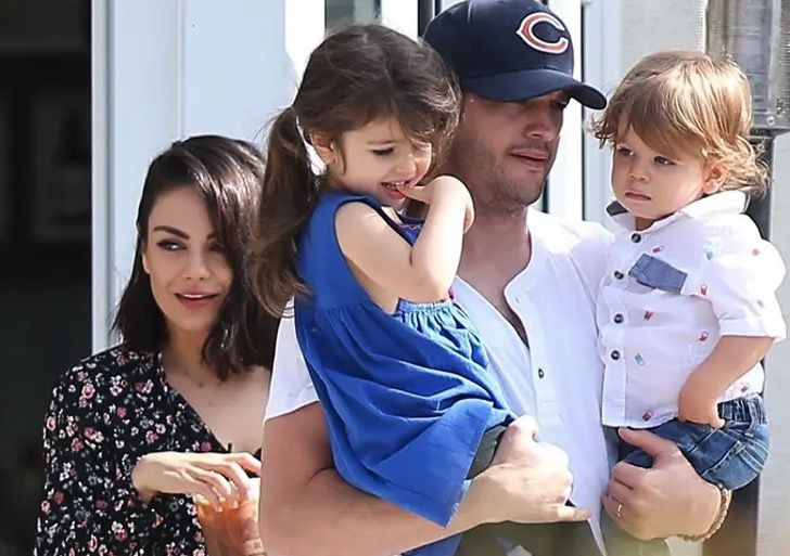 Ashton Kutcher cargando a sus dos hijos