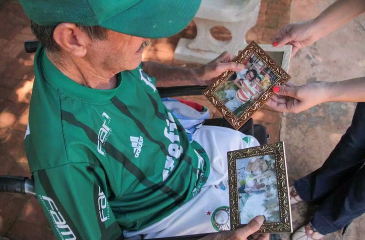 Altamir Soares de Oliveira mirando fotos de su hijo