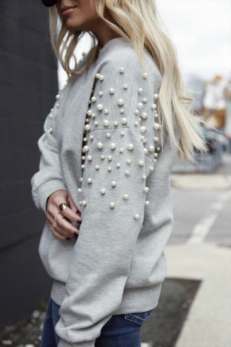 Chica con suéter gris decorado con perlas
