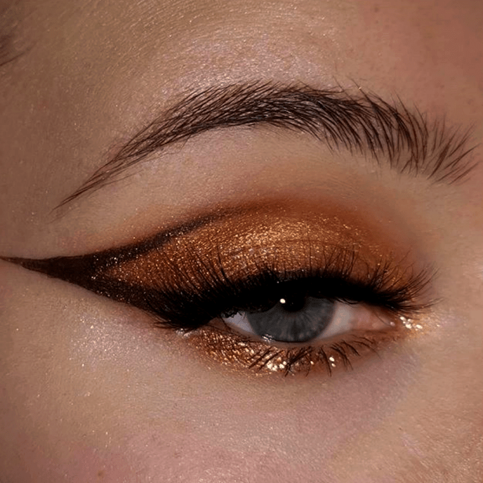 maquillaje de ojos con sombras doradas, amarillas, cafés y delineado café gráfico