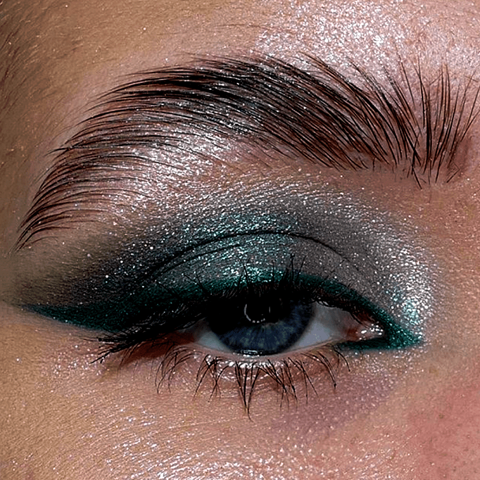 maquillaje de ojos con sombras azules, celestes, delineado turquesa y glitter plateado y dorado