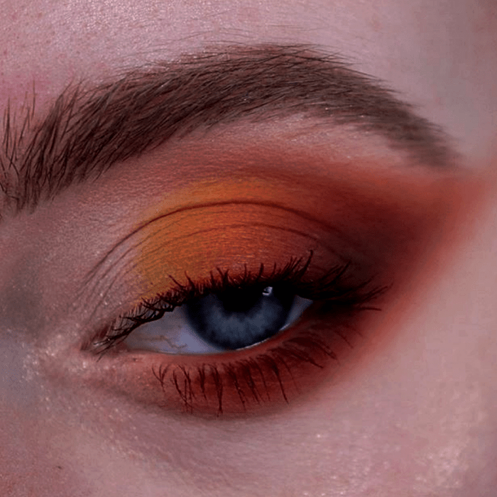 maquillaje de ojos con sombras naranjas, rojas y amarillas, rímel negro
