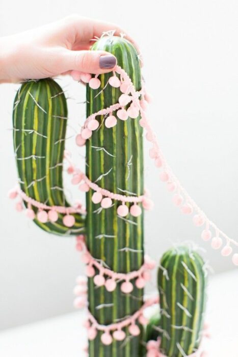 Cactus decorado con una guirnalda rosa pastel con bolitas