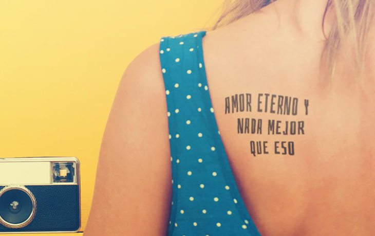 Chica con un tatuaje en la espalda con una leyenda en español