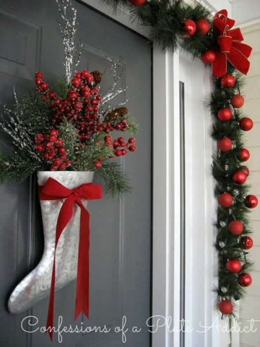 Decoración navideña con guiado verde, esferas rojas y una bota plateada