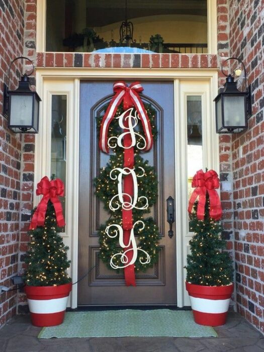 Decoración navideña con luces, pinos y moños rojos