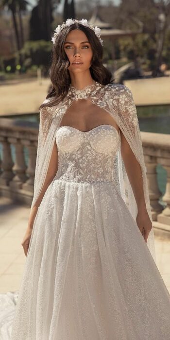 Chica usando un vestido blanco con encaje y una larga capa