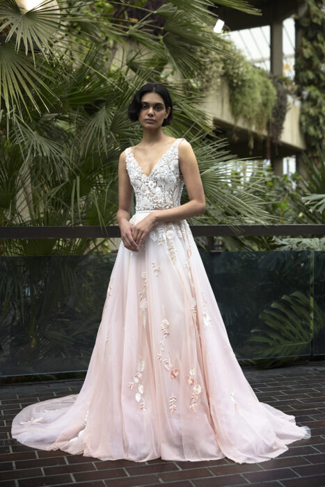 Chica con un vestido rosa con detalles brillantes en flores y mariposas