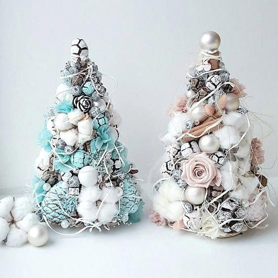 Arbolito de Navidad azul turquesa con detalles blancos y un arbolito blanco con decoración beige y esferas blancas