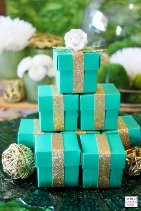 Cajitas de regalos color turquesa con moños dorados y diamantina